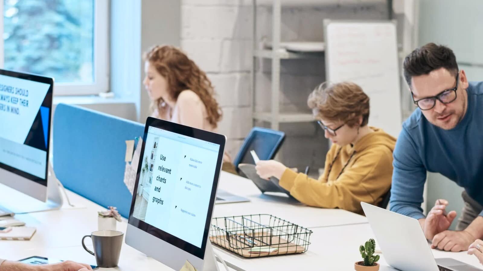 Quality Assurance: eine Gruppe von Mitarbeitern sitzt im Büro und arbeitet mit den Computern
