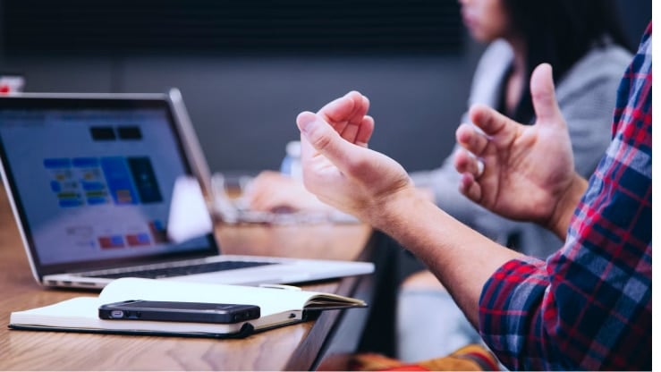 Arbeitnehmerüberlassung, IT-Zeitarbeit: Meeting in einem IT-Projekt, Fokus auf eine Präsentation auf einem Laptop-Bildschirm