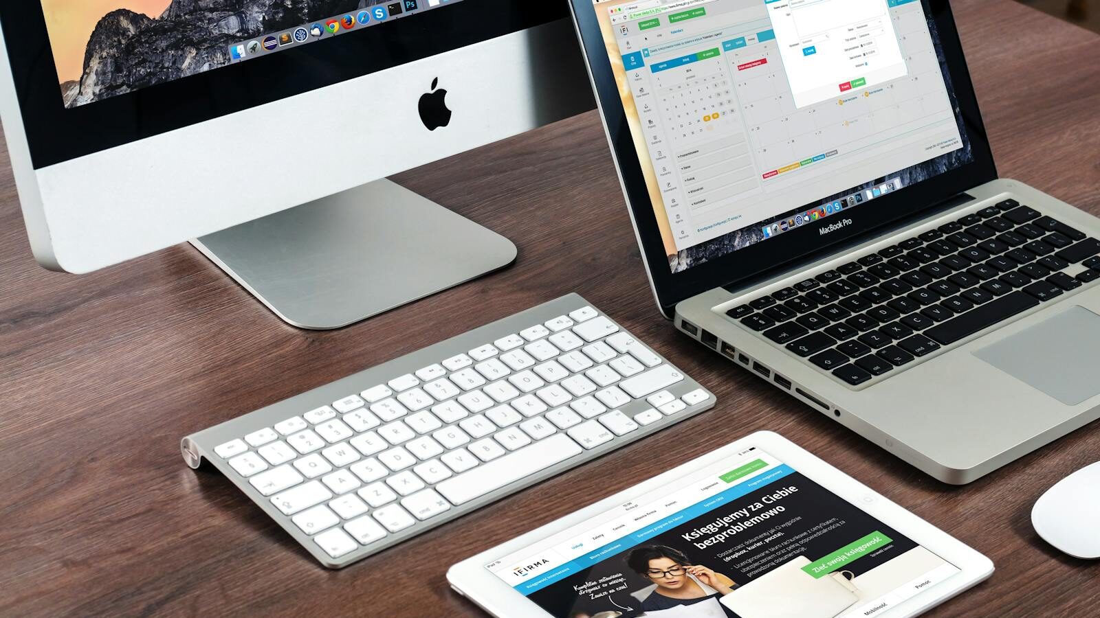 Web-Entwicklung: Win moderner Büro-Schreibtisch-Setup mit Apple-Geräten: iMac, MacBook, und iPad.