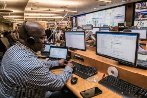 IT-Fachkräftemangel: Ein fokussierter Mann im Büro arbeitet an seinem Computer, recherchiert und kommuniziert.