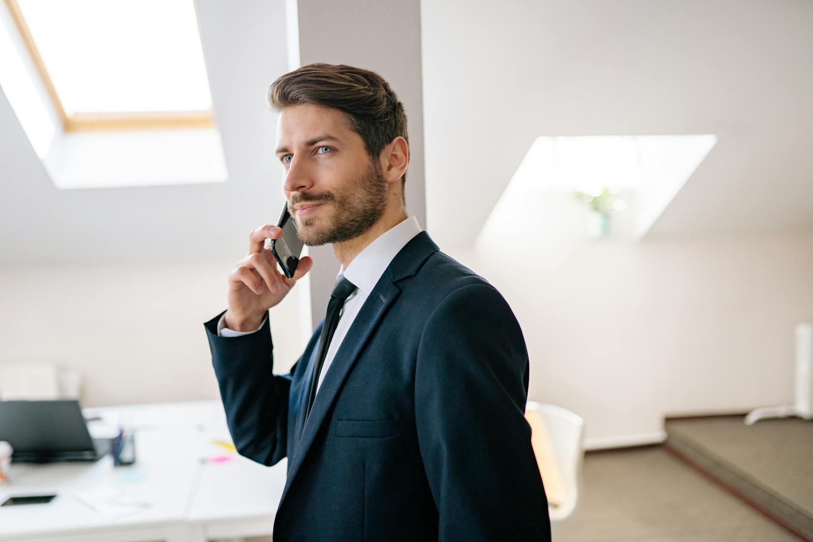 Freelancer Vermittlung - Foto von einem telefonierenden Mann im Anzug, in einem Büro