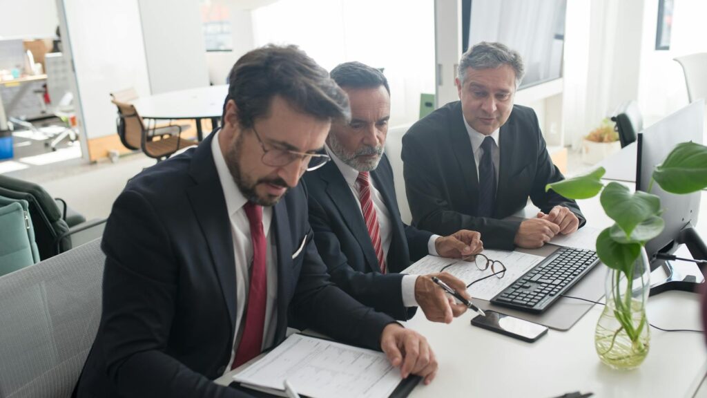 IT-Services: Werkvertrag, Managed Service: Dre Professionelle arbeiten an einem Businessplan in einem modernen Büro zusammen.